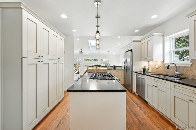 554 S Logan St, Denver, CO 80209 - kitchen featuring appliances with stainless steel finishes, a center island, light wood-type flooring, backsplash, and recessed lighting