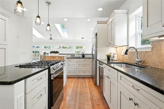 554 S Logan St, Denver, CO 80209 - kitchen featuring stainless steel appliances, a skylight, healthy amount of natural light, light wood finished floors, and recessed lighting
