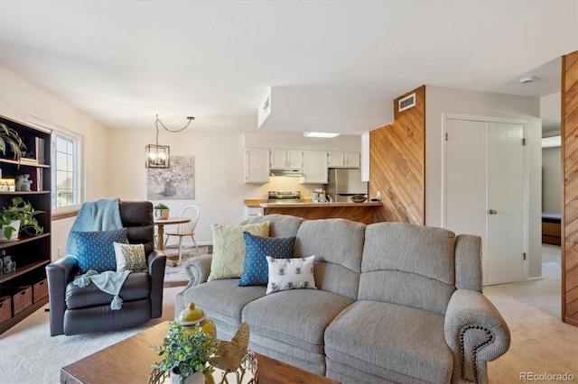 living room featuring a chandelier, light colored carpet, and visible vents