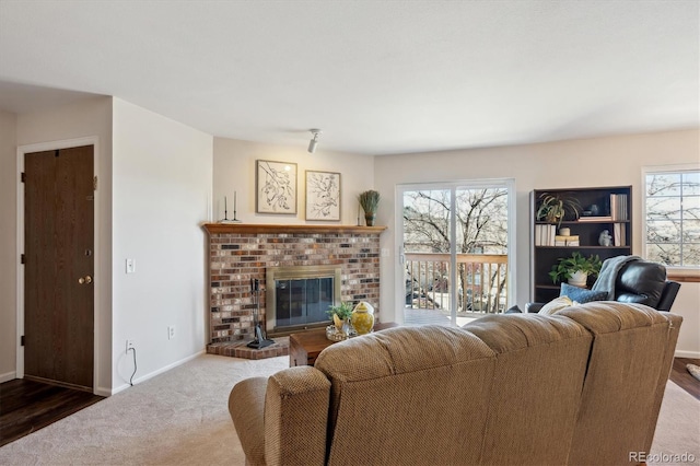 carpeted living room with a fireplace and baseboards