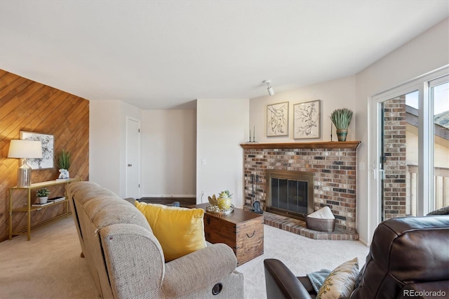 living area featuring light carpet, wood walls, and a brick fireplace