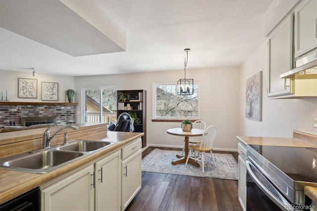 kitchen featuring electric range, dark wood finished floors, dishwasher, light countertops, and a sink