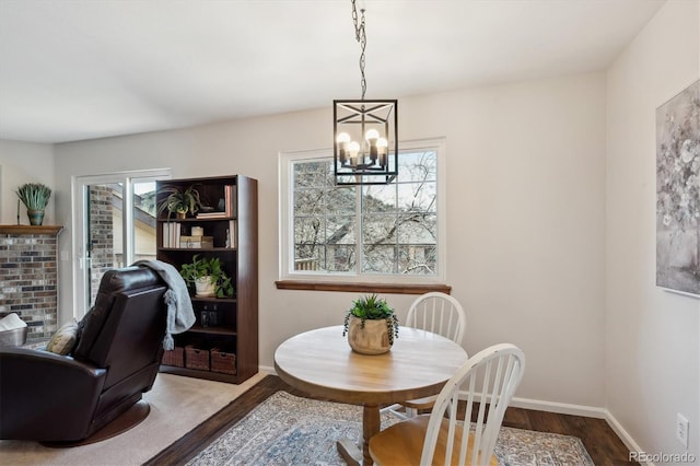 dining space featuring a notable chandelier, baseboards, and dark wood-style flooring