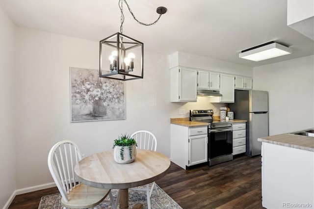 kitchen featuring light countertops, appliances with stainless steel finishes, dark wood-style flooring, and under cabinet range hood