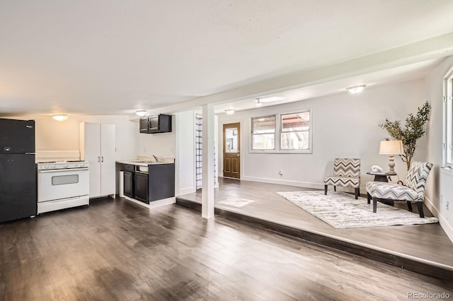 1115 W Quincy Ave, Englewood, CO 80110 - kitchen featuring white range with gas stovetop, freestanding refrigerator, dark wood-style floors, light countertops, and baseboards