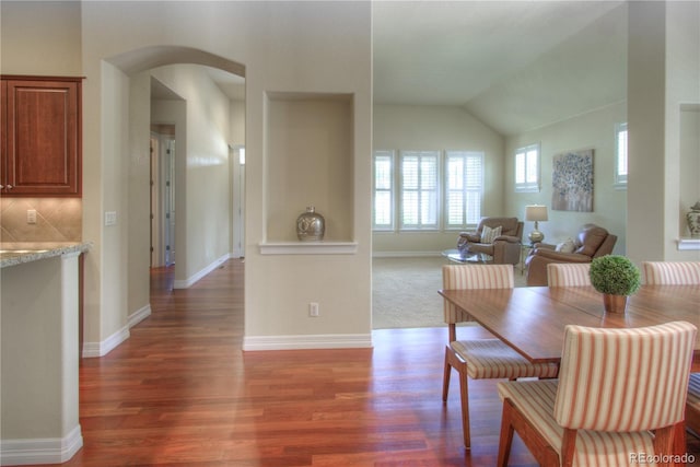 8594 W Quarto Ave, Littleton, CO 80128 - dining space featuring wood finished floors, arched walkways, and lofted ceiling