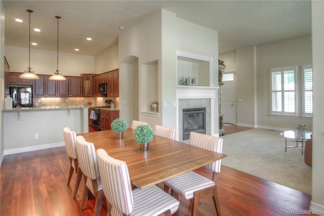 8594 W Quarto Ave, Littleton, CO 80128 - dining room with a tile fireplace, recessed lighting, dark wood-style floors, and a towering ceiling