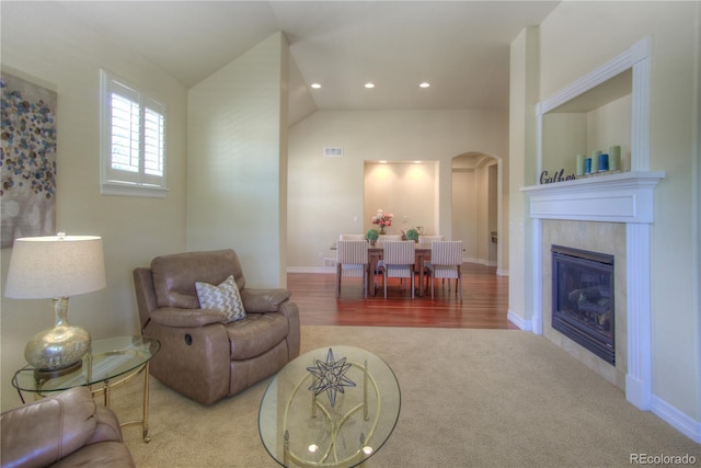 8594 W Quarto Ave, Littleton, CO 80128 - carpeted living room featuring arched walkways, a fireplace, recessed lighting, vaulted ceiling, and wood finished floors