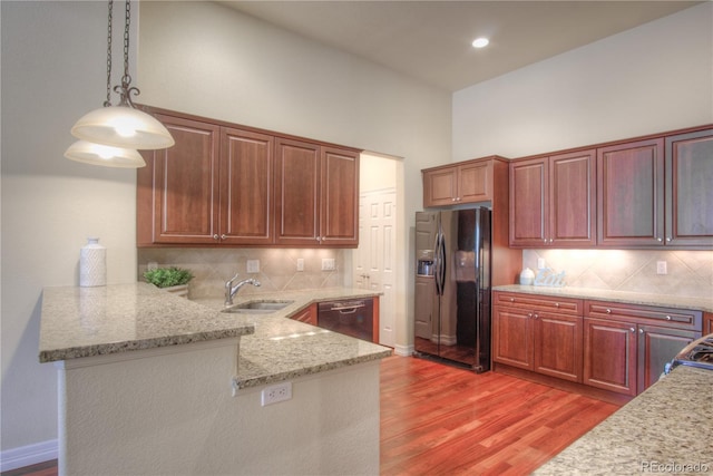 8594 W Quarto Ave, Littleton, CO 80128 - kitchen featuring refrigerator with ice dispenser, dishwashing machine, light wood-style flooring, a peninsula, and hanging light fixtures