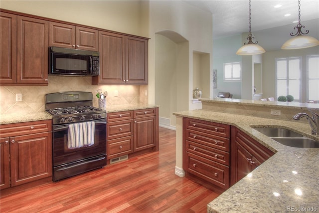8594 W Quarto Ave, Littleton, CO 80128 - kitchen featuring black appliances, light wood finished floors, pendant lighting, and decorative backsplash
