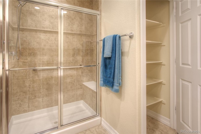8594 W Quarto Ave, Littleton, CO 80128 - bathroom featuring a stall shower and a walk in closet