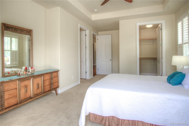 8594 W Quarto Ave, Littleton, CO 80128 - bedroom featuring light carpet, a tray ceiling, a spacious closet, and a closet
