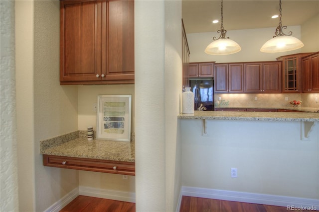 8594 W Quarto Ave, Littleton, CO 80128 - kitchen featuring fridge, glass insert cabinets, a breakfast bar area, dark wood-style flooring, and pendant lighting
