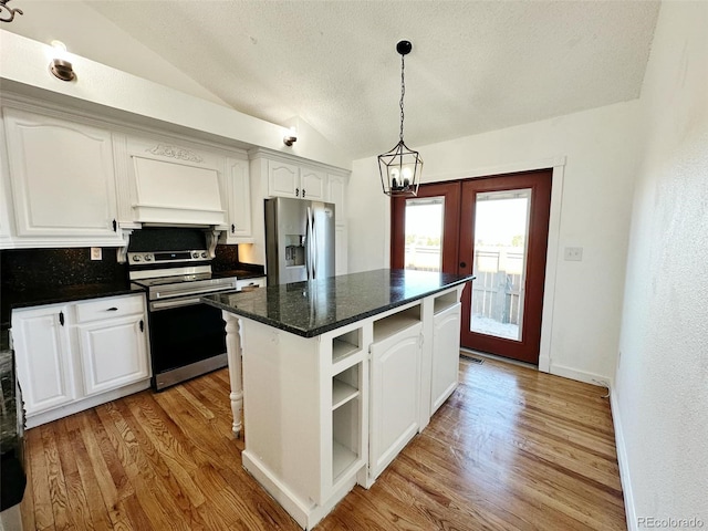 kitchen with hanging light fixtures, stainless steel appliances, a kitchen island, vaulted ceiling, and white cabinets