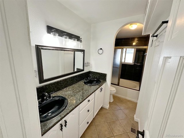 full bathroom featuring tile patterned flooring, toilet, combined bath / shower with glass door, and vanity