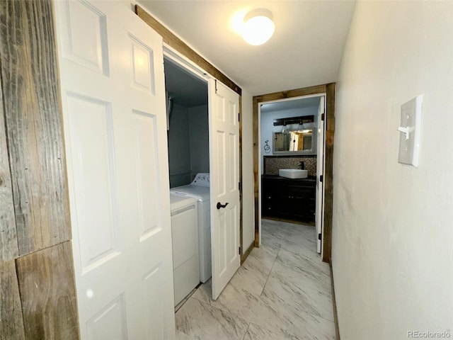 hall with a barn door, separate washer and dryer, and sink