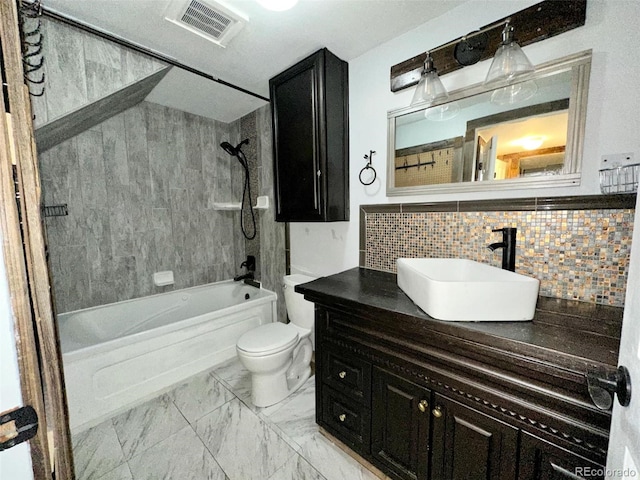 full bathroom featuring toilet, vanity, backsplash, and tiled shower / bath combo