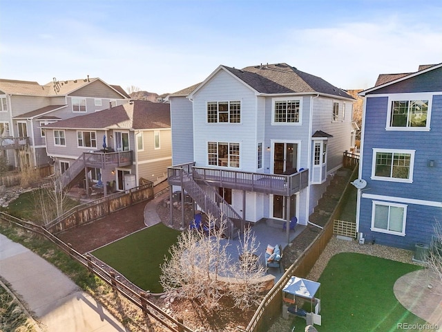 back of house featuring stairway, a residential view, central AC unit, a deck, and a garage