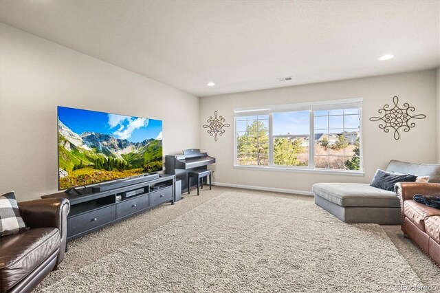 carpeted living area featuring recessed lighting and baseboards
