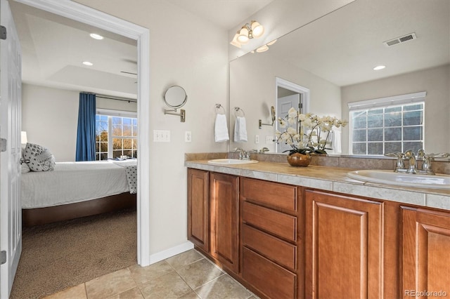 full bathroom with tile patterned floors, ensuite bathroom, double vanity, recessed lighting, and baseboards