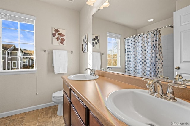 bathroom with baseboards, toilet, curtained shower, and double vanity