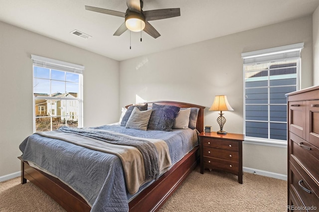 bedroom featuring light colored carpet, baseboards, and ceiling fan