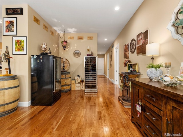 interior space featuring recessed lighting, wine cooler, light wood-style floors, and freestanding refrigerator