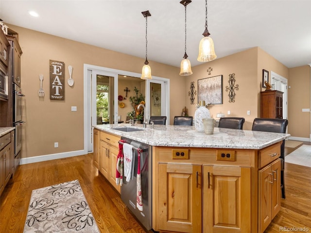 kitchen with dark wood-type flooring, an island with sink, appliances with stainless steel finishes, and a sink