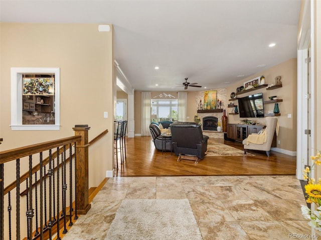 living room featuring a ceiling fan, recessed lighting, a fireplace, and baseboards