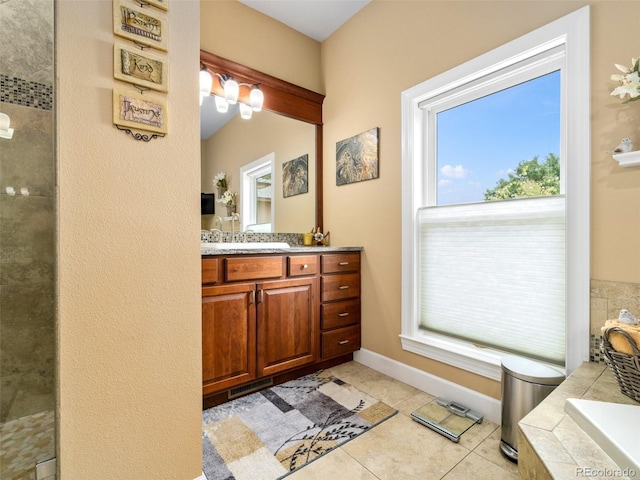 bathroom with a tile shower, tile patterned flooring, baseboards, tiled tub, and vanity