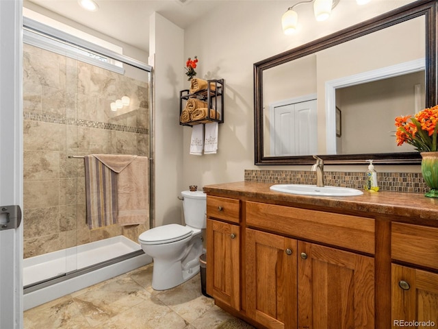 full bathroom featuring vanity, toilet, tasteful backsplash, and a stall shower