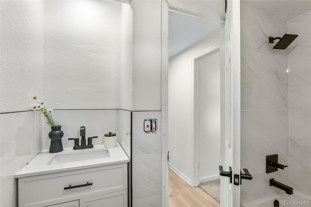 5640 Niagara St, Commerce City, CO 80022 - bathroom featuring vanity, washtub / shower combination, and wood finished floors