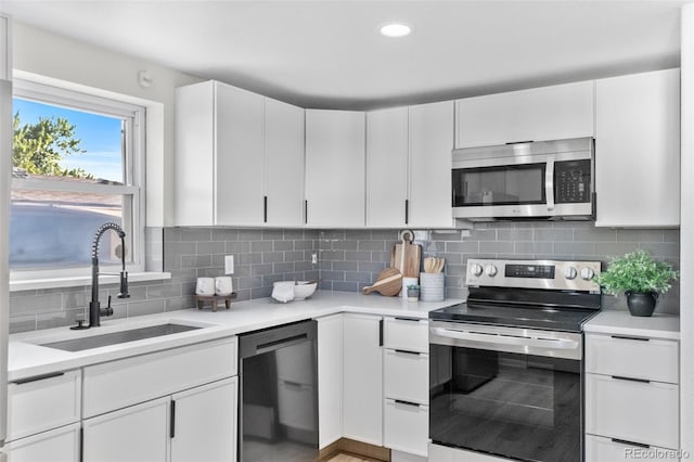 5640 Niagara St, Commerce City, CO 80022 - kitchen featuring appliances with stainless steel finishes, light countertops, white cabinetry, decorative backsplash, and recessed lighting