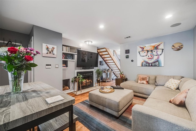 1150 Inca St Unit 43, Denver, CO 80204 - living room featuring wood finished floors, a fireplace with flush hearth, stairs, and recessed lighting