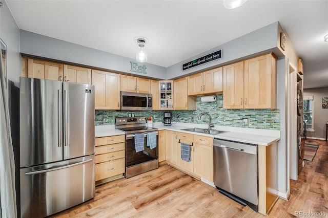 1150 Inca St Unit 43, Denver, CO 80204 - kitchen featuring stainless steel appliances, light brown cabinets, a sink, light wood-style floors, and tasteful backsplash