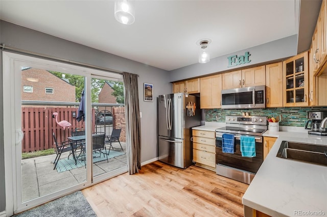 1150 Inca St Unit 43, Denver, CO 80204 - kitchen with appliances with stainless steel finishes, a sink, light countertops, and decorative backsplash