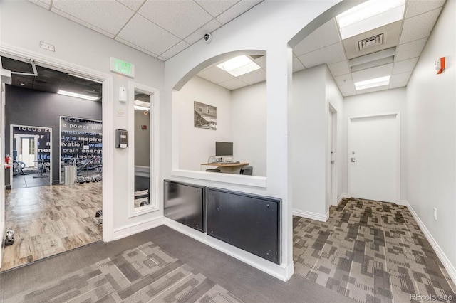 1150 Inca St Unit 43, Denver, CO 80204 - hall with a drop ceiling, carpet flooring, arched walkways, and baseboards