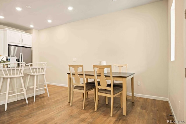 dining room featuring baseboards, light wood-style floors, and recessed lighting