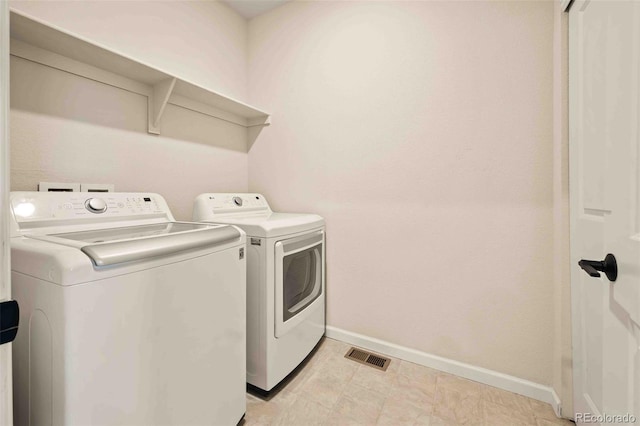 laundry area with washing machine and dryer, laundry area, baseboards, and visible vents