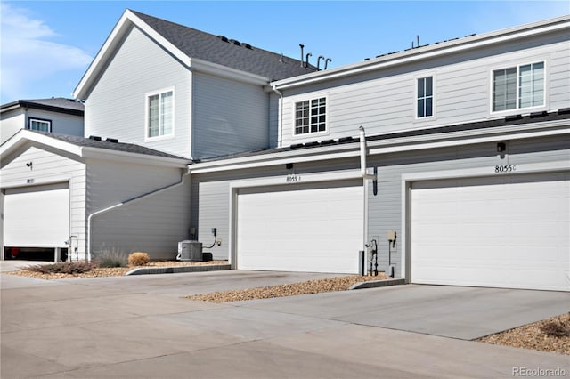 view of front of home featuring central AC, driveway, and a garage