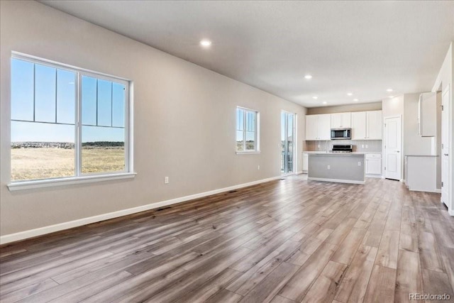 unfurnished living room featuring light hardwood / wood-style floors and plenty of natural light