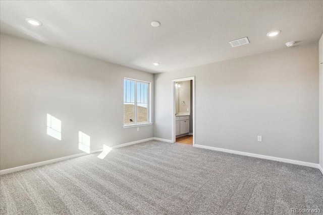 spare room featuring light colored carpet