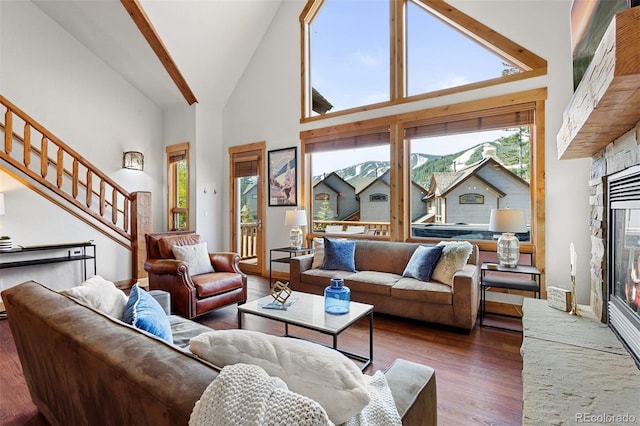 200 Antler Way, Winter Park, CO 80482 - living area with a stone fireplace, high vaulted ceiling, wood finished floors, and stairs