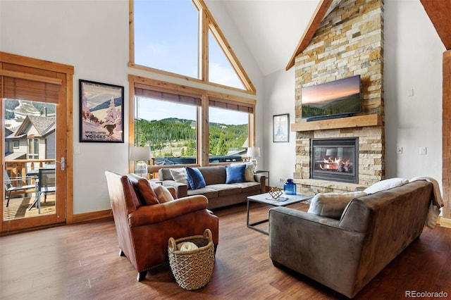 200 Antler Way, Winter Park, CO 80482 - living room featuring wood finished floors, a stone fireplace, high vaulted ceiling, and baseboards