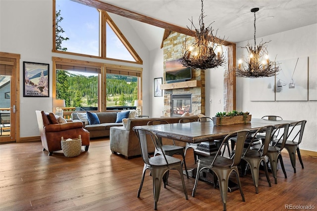 200 Antler Way, Winter Park, CO 80482 - dining area featuring a chandelier, wood finished floors, a fireplace, high vaulted ceiling, and beam ceiling