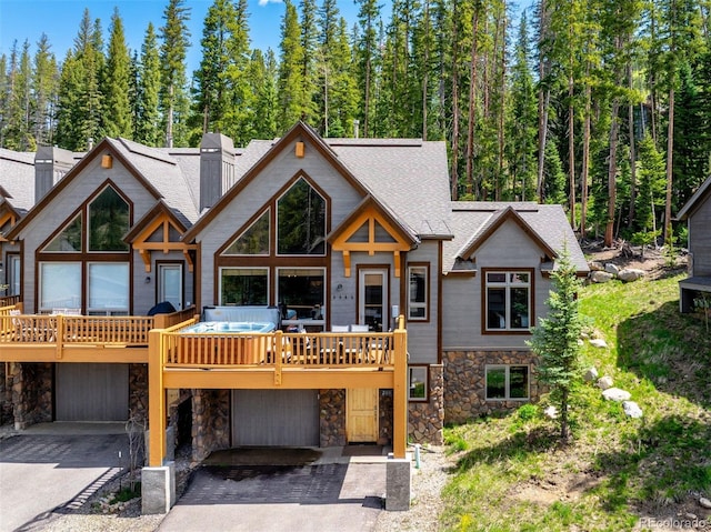 200 Antler Way, Winter Park, CO 80482 - view of front of property with stone siding, driveway, a deck, and roof with shingles