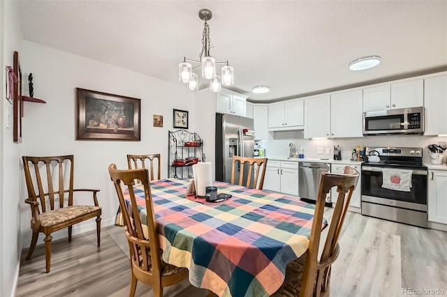 dining room with light wood-type flooring and baseboards