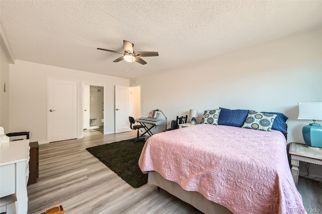 bedroom with baseboards, light wood-style flooring, a ceiling fan, and a textured ceiling