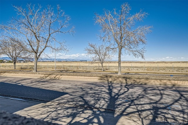 view of yard with a rural view and fence