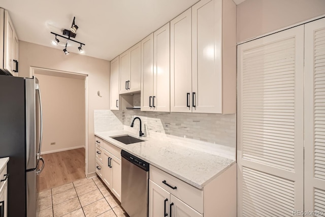 kitchen featuring white cabinets, light stone counters, sink, and stainless steel appliances